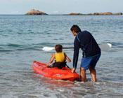 Father helping son launch canoe
