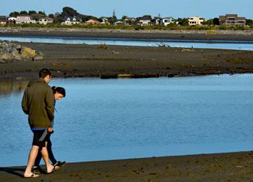 A young couple walking along the estuary